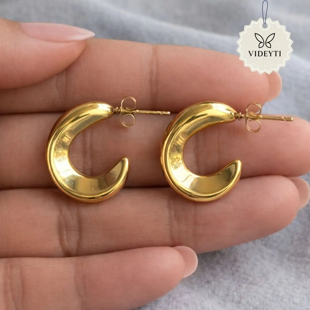 Gold crescent-shaped stud earrings with polished finish