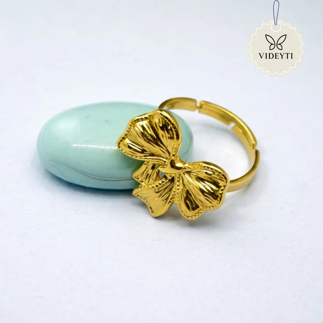 Gold adjustable stainless steel ring with vintage bow design and polished finish.