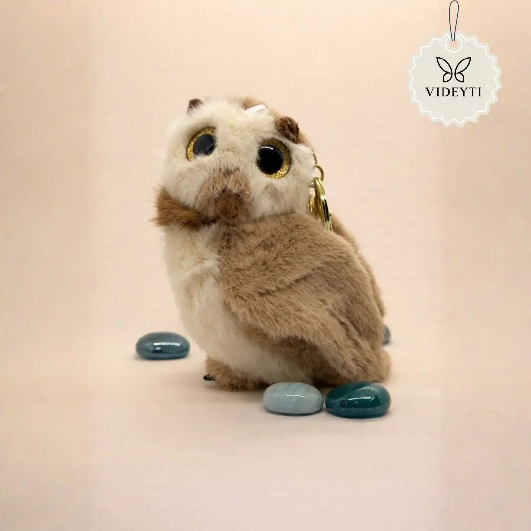 Cute plush owl bag charm with soft brown fur, large shiny eyes, and a gold keychain ring