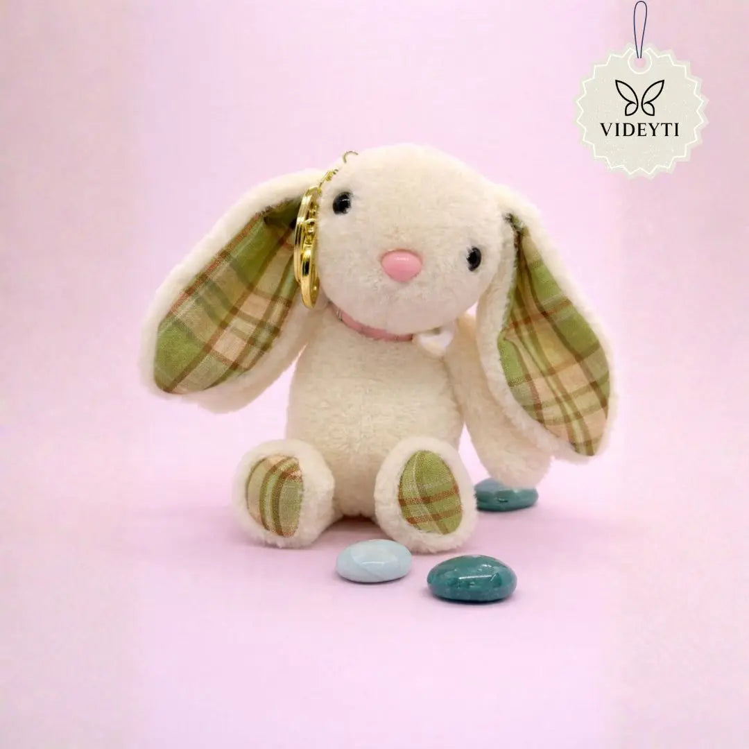 Cream plush bunny bag charm with green plaid ears and matching paws and a gold keychain ring.