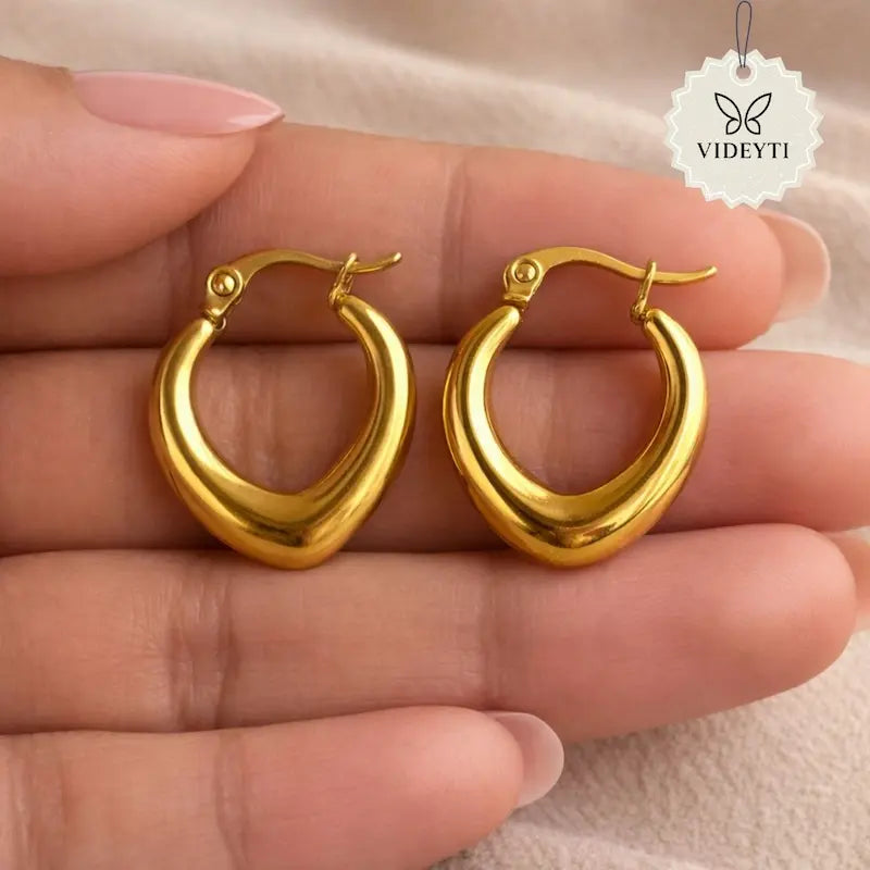 Teardrop-shaped gold-tone hoop earrings with curved silhouette