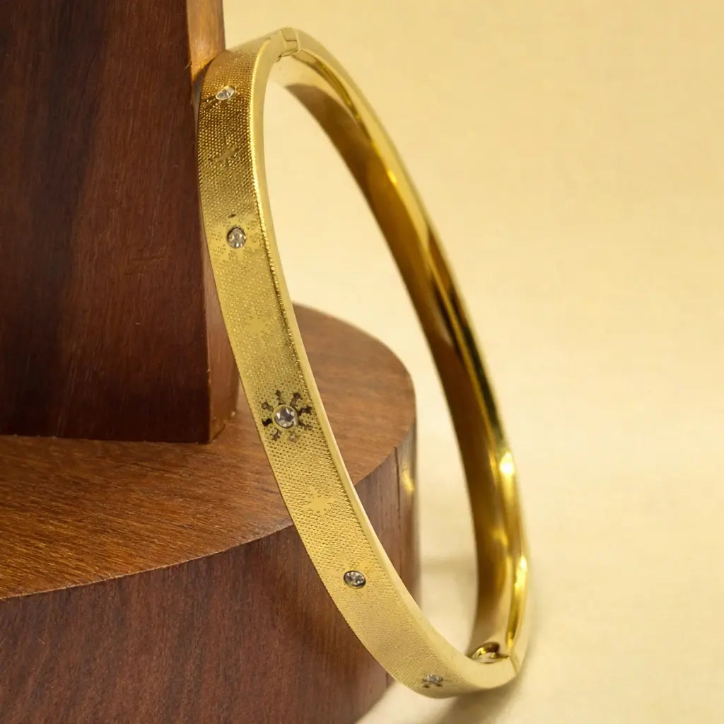 Golden textured bangle with subtle crystal dot accents