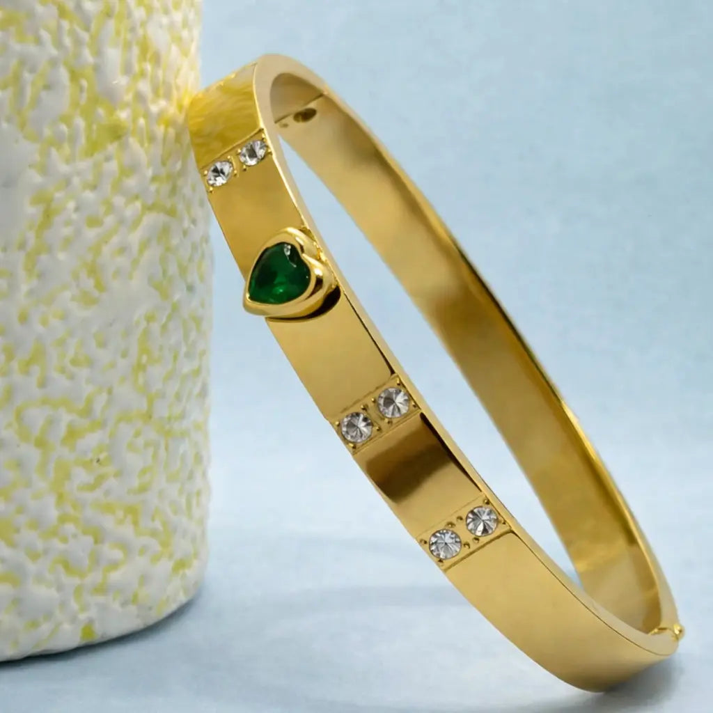 Golden bangle bracelet with green stone and crystal accents