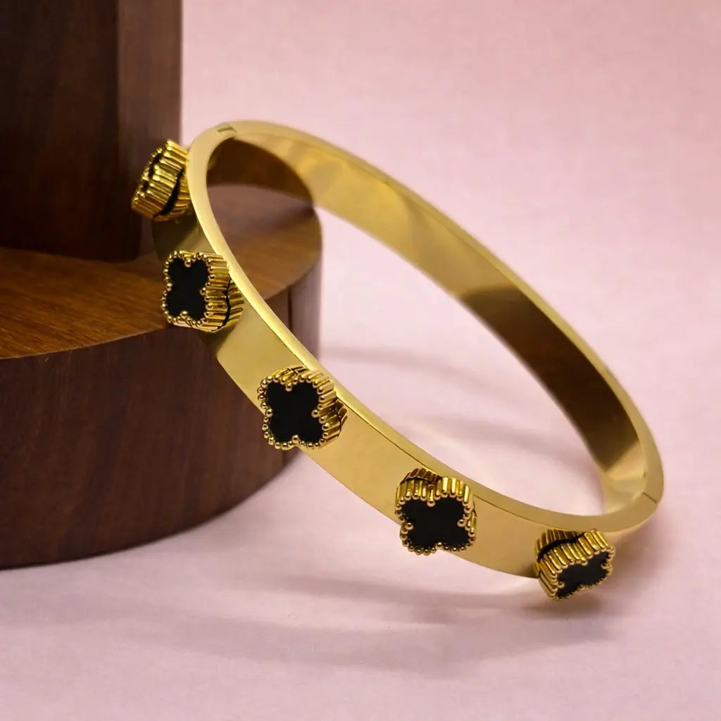 Golden bangle bracelet with multiple black clover charms